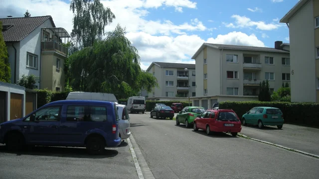 Immeuble résidentiel dans un quartier urbain suisse avec façade classique et balcons.