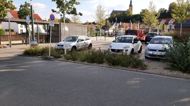 Vue aérienne d'un parc-relais avec places de stationnement et bus de transport en commun à la frontière franco-suisse.